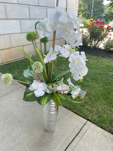 White orchid flower arrangement with silver vase