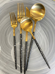 Black and gold 20 piece flatware set with white splash design