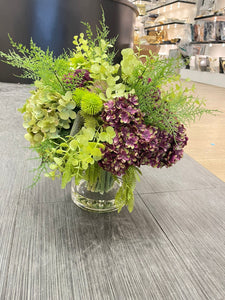 Green and Purple Flower arrangement with Clear Vase